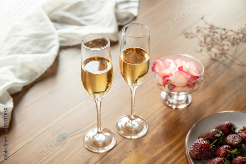 Glasses of sparkling champagne with sweets, close up. Warm colored. Celebration event, holidays, drinks concept. Companion for best family or friend's memories. Anniversary, wedding day or Christmas