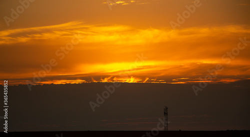 Tongues of flame from behind the clouds at sunset  beautiful red sunset behind the clouds.