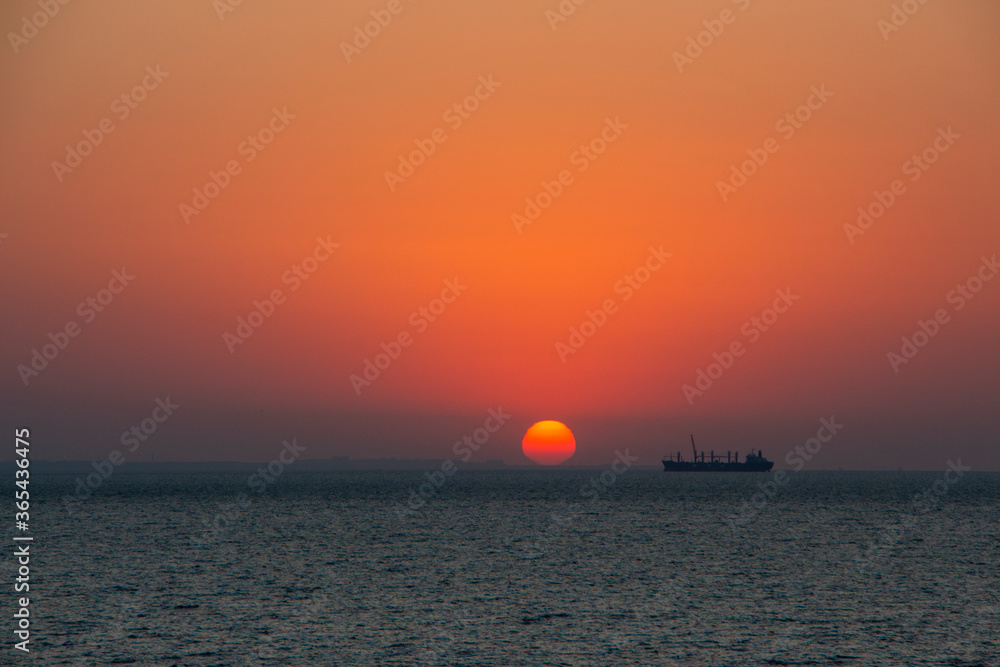 Silhouette of a fishing ship on a background of sunrise. Sunrise in the morning by the sea.
