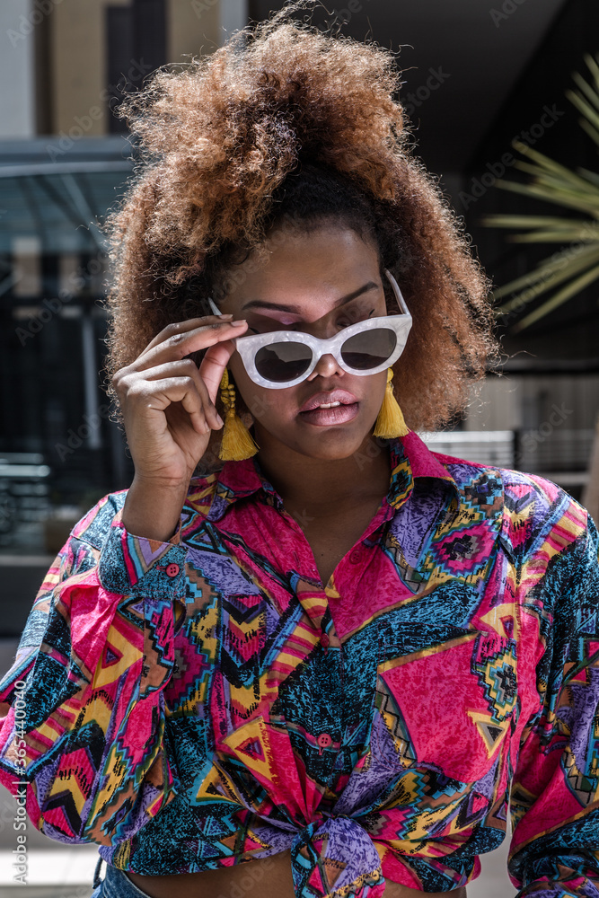 Stylish African American woman in sunglasses on street Stylish African American woman in sunglasses on street