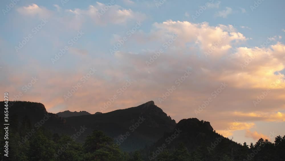 Rocky mountain peak with beautiful sunset behind with colorful cloudscape Rocky mountain peak with beautiful sunset behind with colorful cloudscape