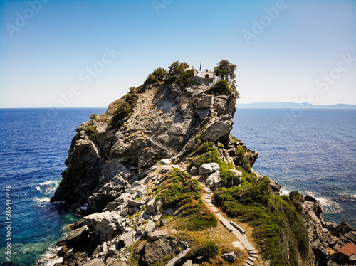 Fotografie, Obraz The church of Agios Ioannis on the Mamma Mia Cliff on the island of Skopelos, shaken by the blue Mediterranean sea