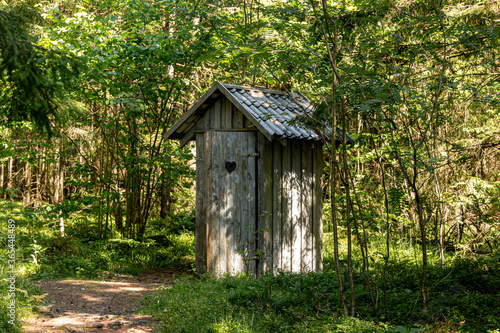 Photos Old wooden toilet in the woods. Outhouse in the wood.