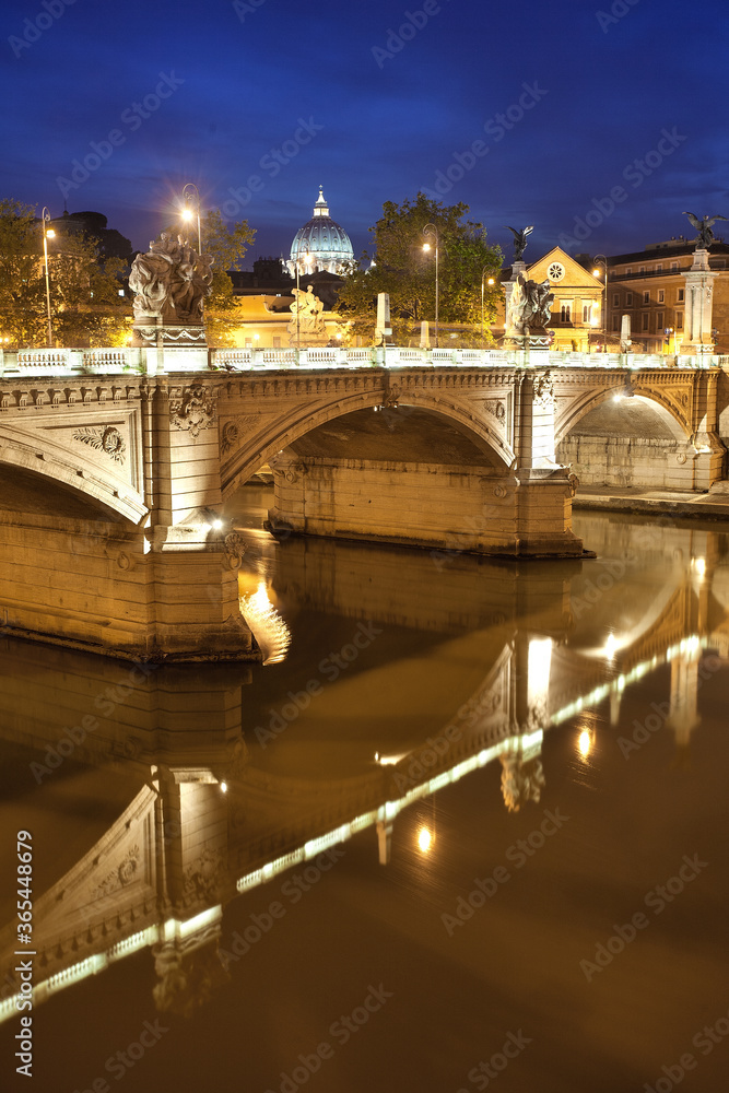 Blick auf die Kuppel des Petersdom und einer Brücke bei Nacht zur blauen Stunde mit Spiegelung