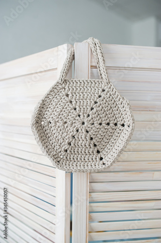 Empty eco bag hanging on wooden door.