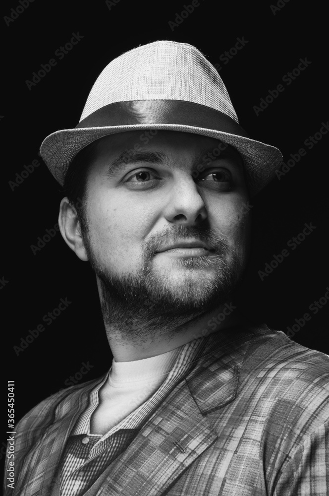 black and white image if handsome bearded confident man in hat with ribbon looking away black and white image if handsome bearded confident man in hat with ribbon looking away