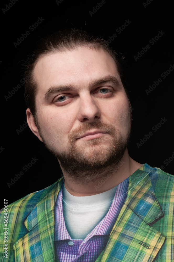 Obraz premium low key portrait of good looking bearded man in green blazer looking at camera isolated on black