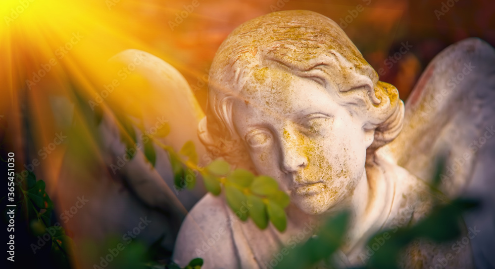 Sad eyes of angel in sunlight. Ancient stone statue. Death, pain and end of life concept.