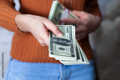 Businesswoman hands displaying a spread of cash.