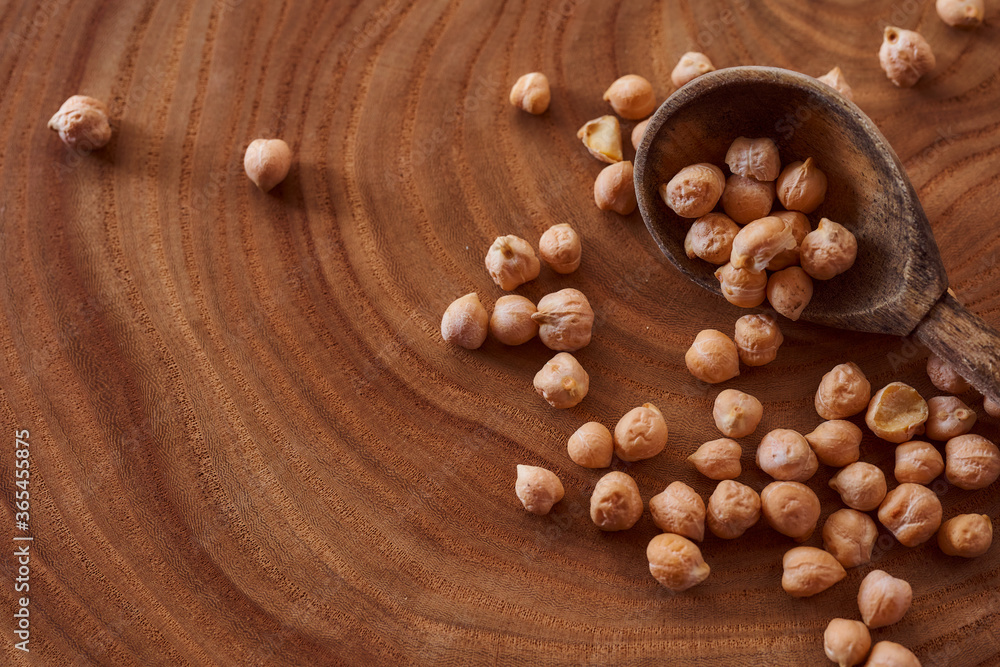 Superfood chickpeas lie in wooden background with spoon. Close-up. Top view. Superfood chickpeas lie in wooden background with spoon. Close-up. Top view.