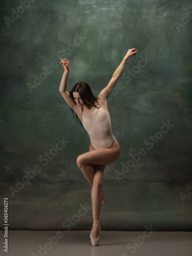 Artwork. Graceful classic ballerina dancing on dark studio background. Pastel bodysuit. The grace, artist, movement, action and motion concept. Looks weightless, flexible. Fashion, style.
