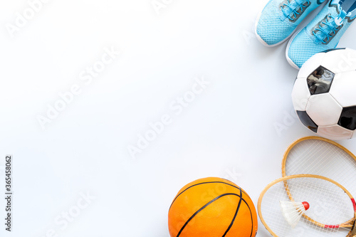 Sport games equipment - balls, sneakers, rockets - on white top view copy space