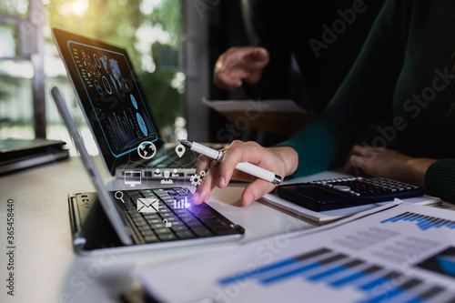 Double exposure of businesswoman working on digital tablet and laptop with digital marketing virtual chart, Abstract icon, Business strategy concept.