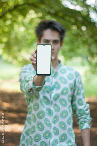 Young man showing phone screen and looking at camera