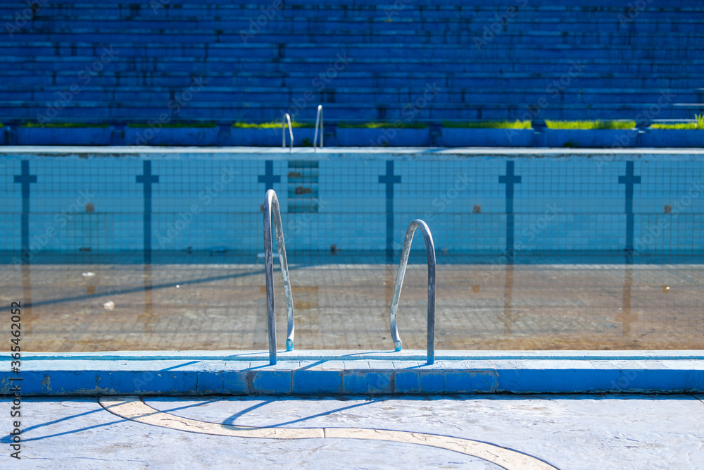 Obraz premium Damaged swimming pool. Old swimming pool with dirty water
