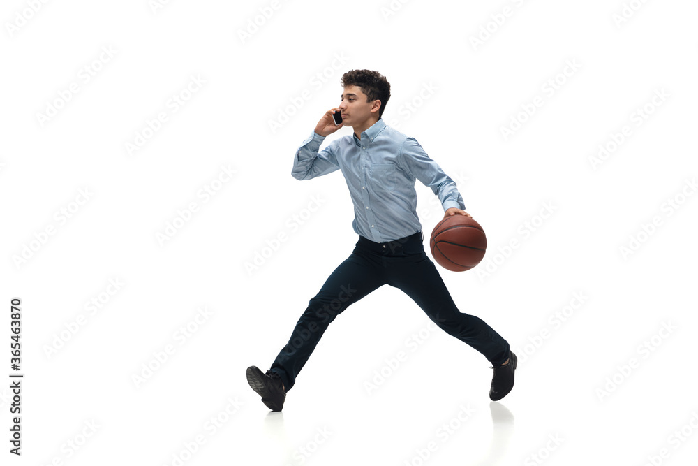 Busy. Man in office clothes playing basketball on white background like professional player, sportsman. Unusual look for businessman in motion, action with ball. Sport, healthy lifestyle, creativity. Busy. Man in office clothes playing basketball on white background like professional player, sportsman. Unusual look for businessman in motion, action with ball. Sport, healthy lifestyle, creativity.