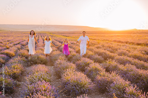 Family in lavender flowers field on the sunset