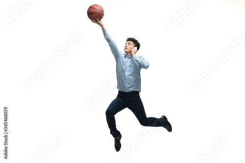 Leader. Man in office clothes playing basketball on white background like professional player, sportsman. Unusual look for businessman in motion, action with ball. Sport, healthy lifestyle, creativity