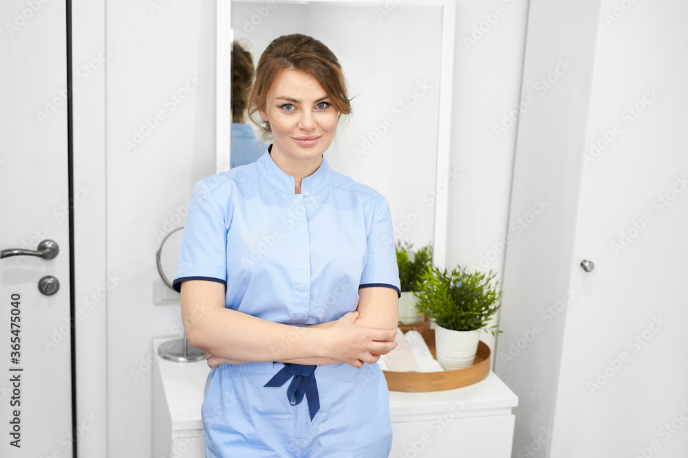 Happy successful young woman cosmetologist on the background of the beauty office. Portrait of prosessional beautician Happy successful young woman cosmetologist on the background of the beauty office. Portrait of prosessional beautician