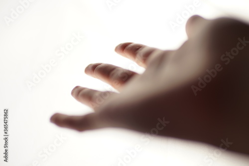 Female hand with palm up and spread fingers on a white background. Blurred soft focus