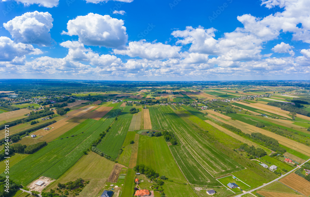 Stunning aerial panorama from a drone of countryside, village, green fields and trees, agriculture concept.