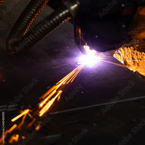 Sparks when cutting metal with a plasma machine at an industrial plant.