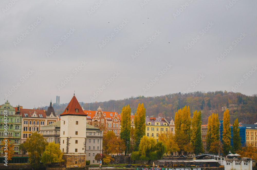 Colourful pastel toned houses full of windows directed to the streets in a cloudy autumn afternoon in Prague, Czechia.