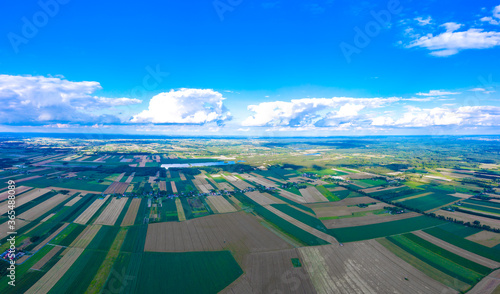 Panoramic aerial view of idyllic rolling patchwork farmland with pretty wooded boundaries, lit in warm early evening sunshine in the heart of the Countryside