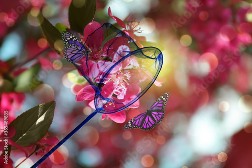 Bright net and beautiful butterflies on blossoming tree outdoors © New Africa