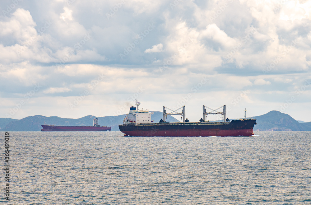 An old bulk carrier or bulker sails in the sea near shore