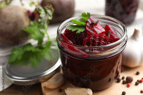 Delicious pickled beets and spices on wooden table, closeup