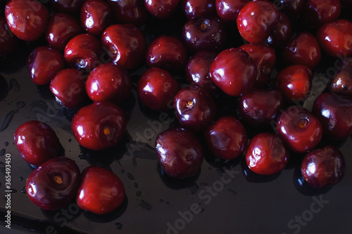 Close-up of wet ripe sweet cherry on a black background