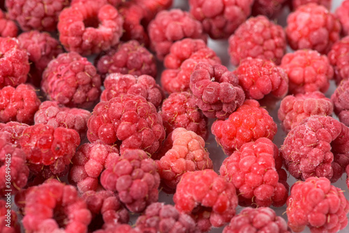 background of frozen raspberries, fresh berries covered with frost, top view. macro photo close-up