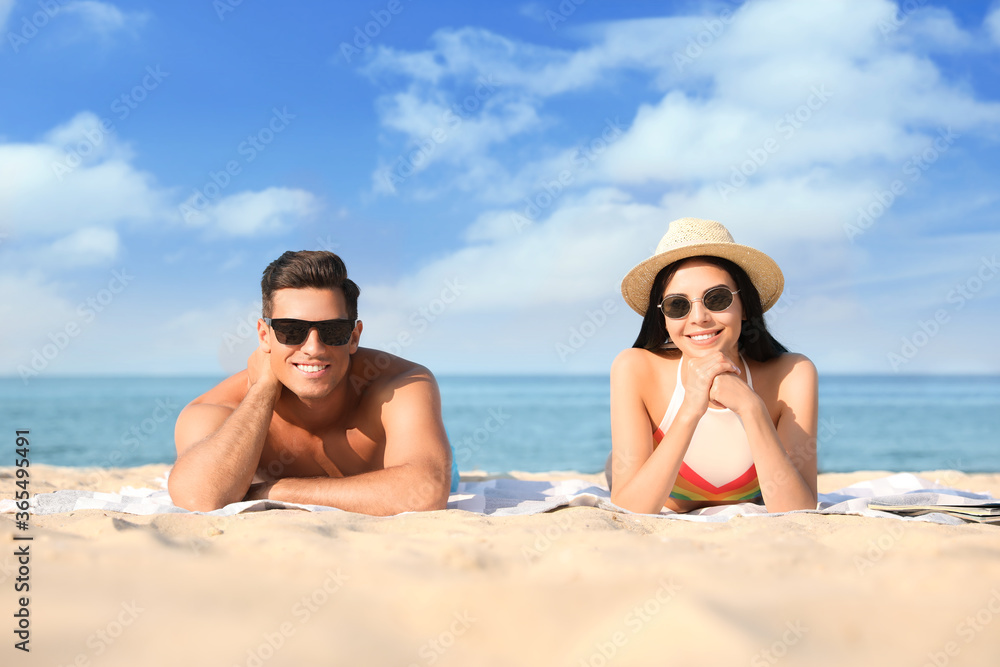 Happy couple resting on sunny beach at resort Happy couple resting on sunny beach at resort