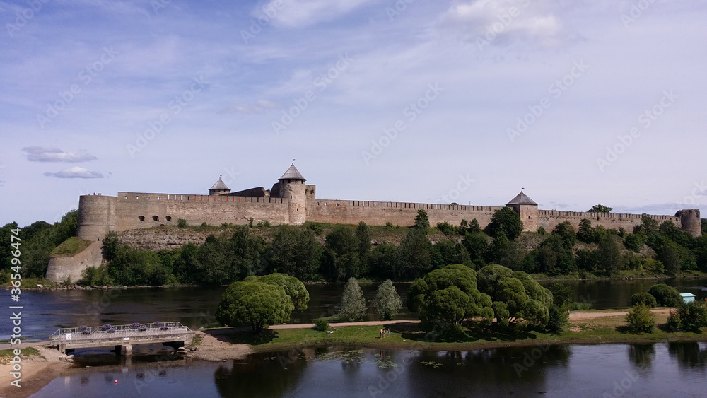 An ancient fortress by the river. Ivangorod, Russia. View from the side of Narva, Estonia.