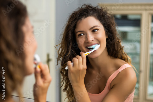 Beautiful woman brushing teeth in the bathroom. 