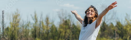 horizontal crop of cheerful woman with outstretched hands smiling outside photo
