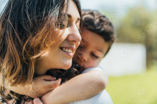 selective focus of cute boy hugging happy mother