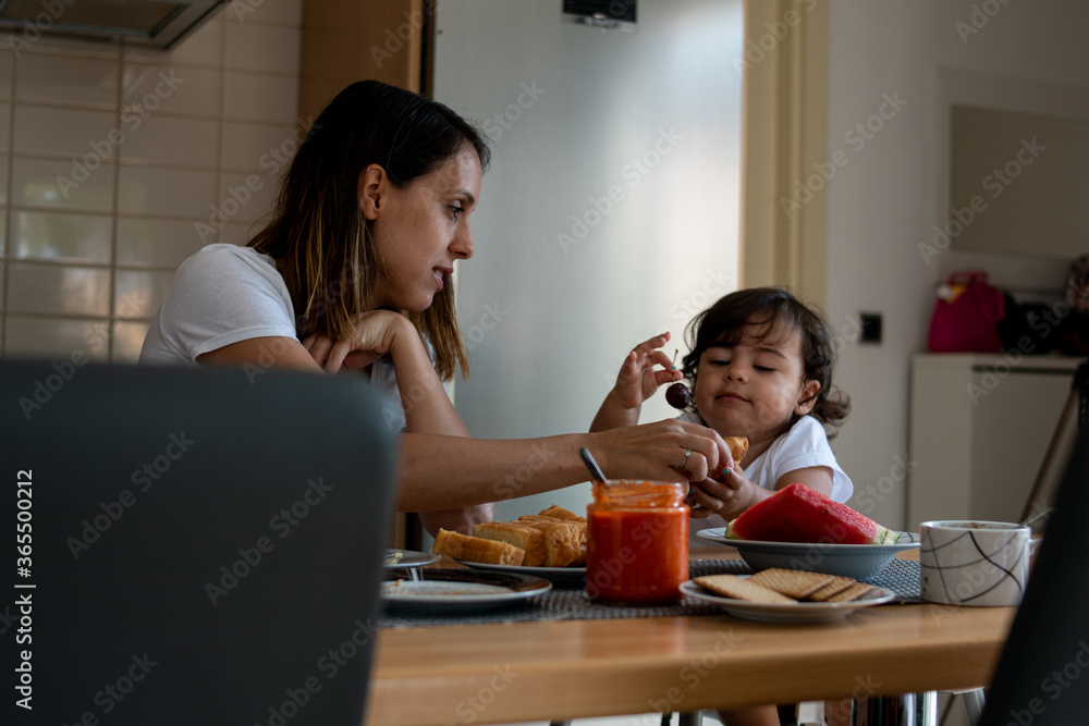 Mother and daughters enjoying a full breakfast together in the kitchen. Mother and daughters enjoying a full breakfast together in the kitchen.