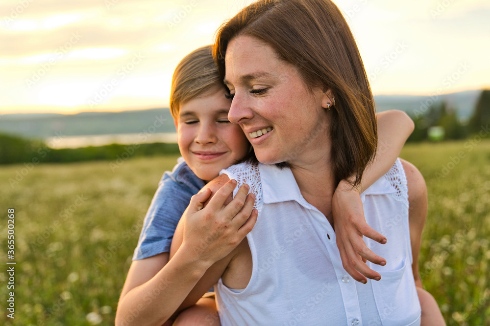 happy family of mother and child on field at the sunset having fun happy family of mother and child on field at the sunset having fun