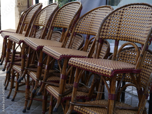 A row of stacked cafe chairs outside a restaurant in Chartres  France.