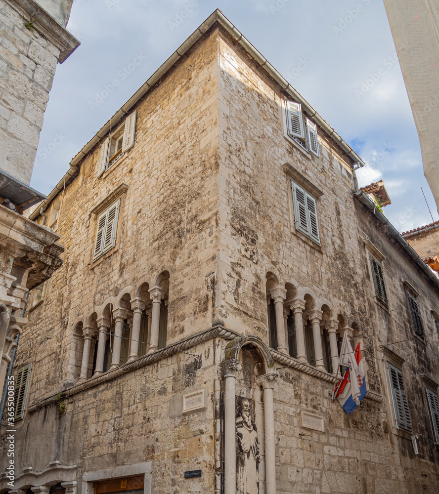 Edificio antiguo con arcos y estatua en las calles estrechas del centro histórico de Split, Croacia, verano de 2019