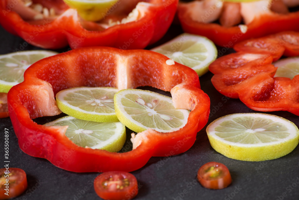 sliced rings of fresh lemon, cherry tomatoes and red bell pepper, close-up sliced rings of fresh lemon, cherry tomatoes and red bell pepper, close-up