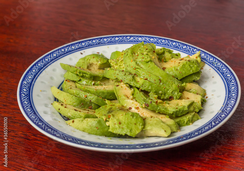 Avocado salad with pepper and lemon juice on a chinese plate