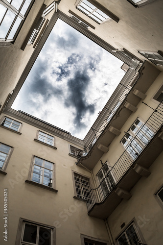 Narrow Courtyard With View Up To The Cloudy Sky Of A Historic Building