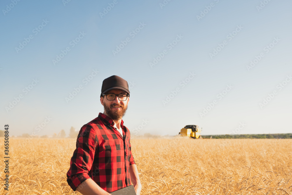Portrait of a man with tablet lin a wheat or rye field. Modern farmer, agriculture business management, local business owner concept Portrait of a man with tablet lin a wheat or rye field. Modern farmer, agriculture business management, local business owner concept