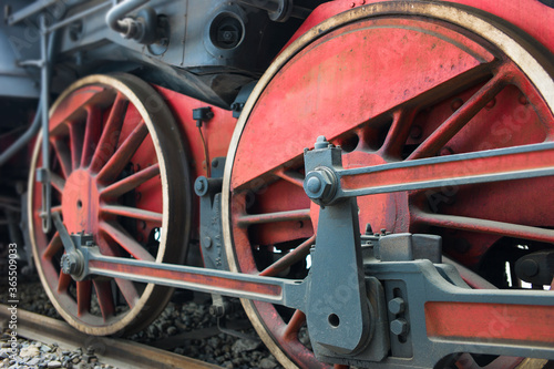 Old red and black locomotive wheels close up. Focus on the right part of the image
