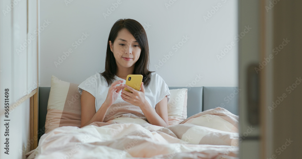 Woman use of mobile phone on bed Woman use of mobile phone on bed