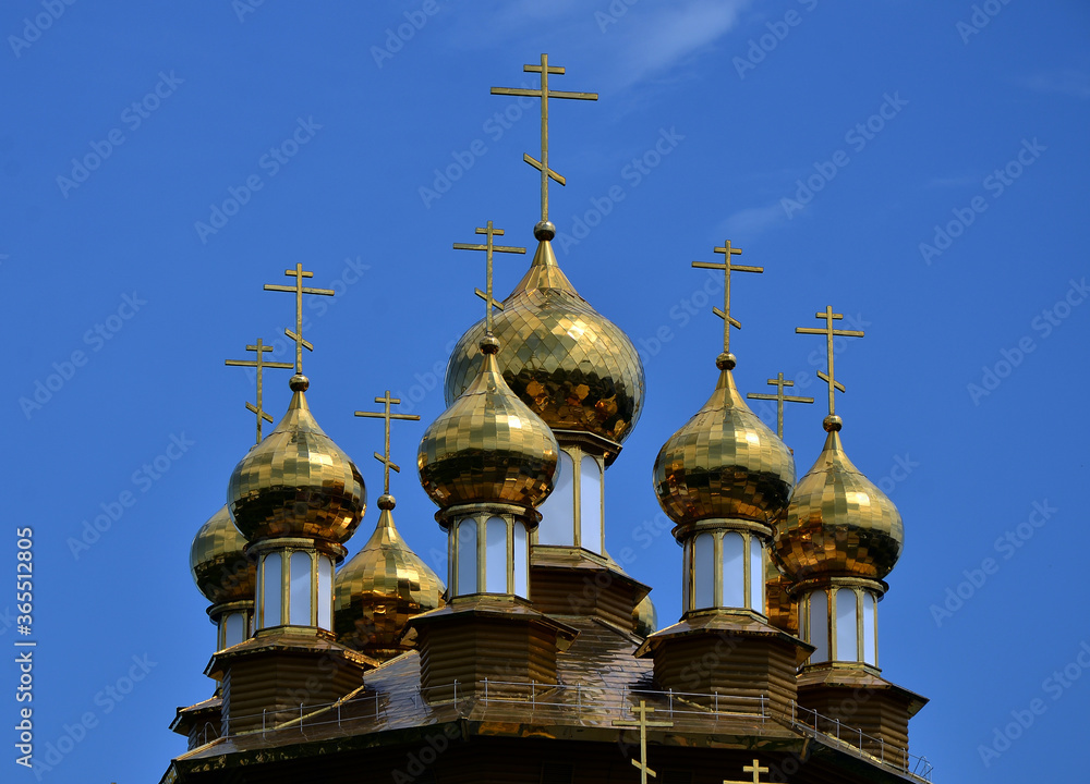 Golden domes of an Orthodox church against a bright blue sky