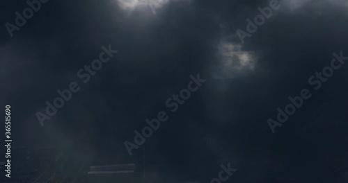 Close up Footage of Black Dense Clouds of Smoke Rising into the Air from the Strongly Burning Industrial Building or Factory and Rolling Across the Sky. photo